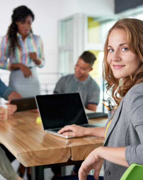 Creative blond businesswoman leading hes team in a friendly conversation about their next agency project